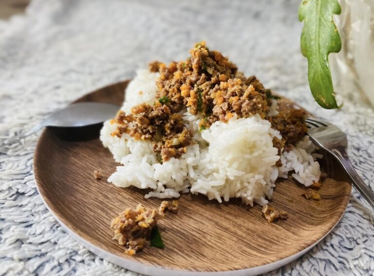 Ground chicken with carrots on top of cooked rice.