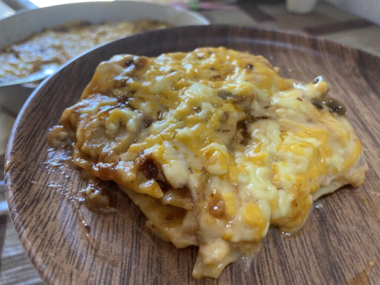 Cheesy lasagna on a wooden plate.