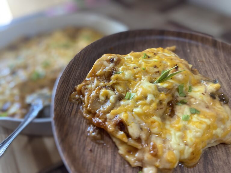 Cheesy lasagna on a wooden plate.