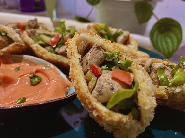 Chicken breast pockets on a plate, with a dipping sauce.